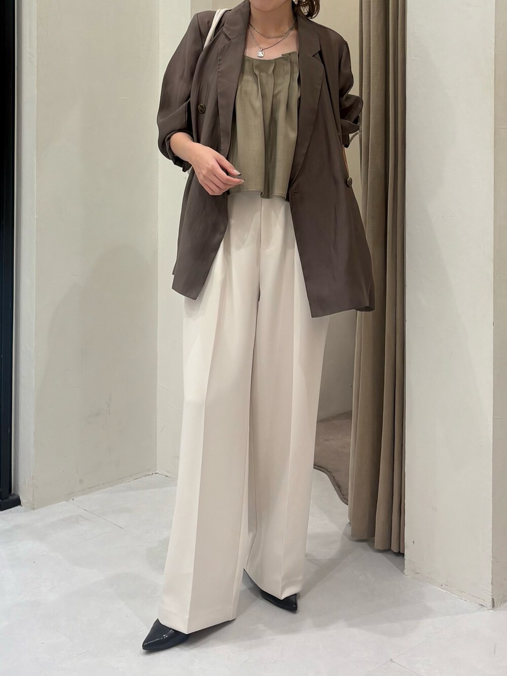 ホワイト系のその他パンツ、ブラック系のパンプス、ベージュ系のシャツ/ブラウスを着用したレディースの秋コーディネートの5枚目の写真