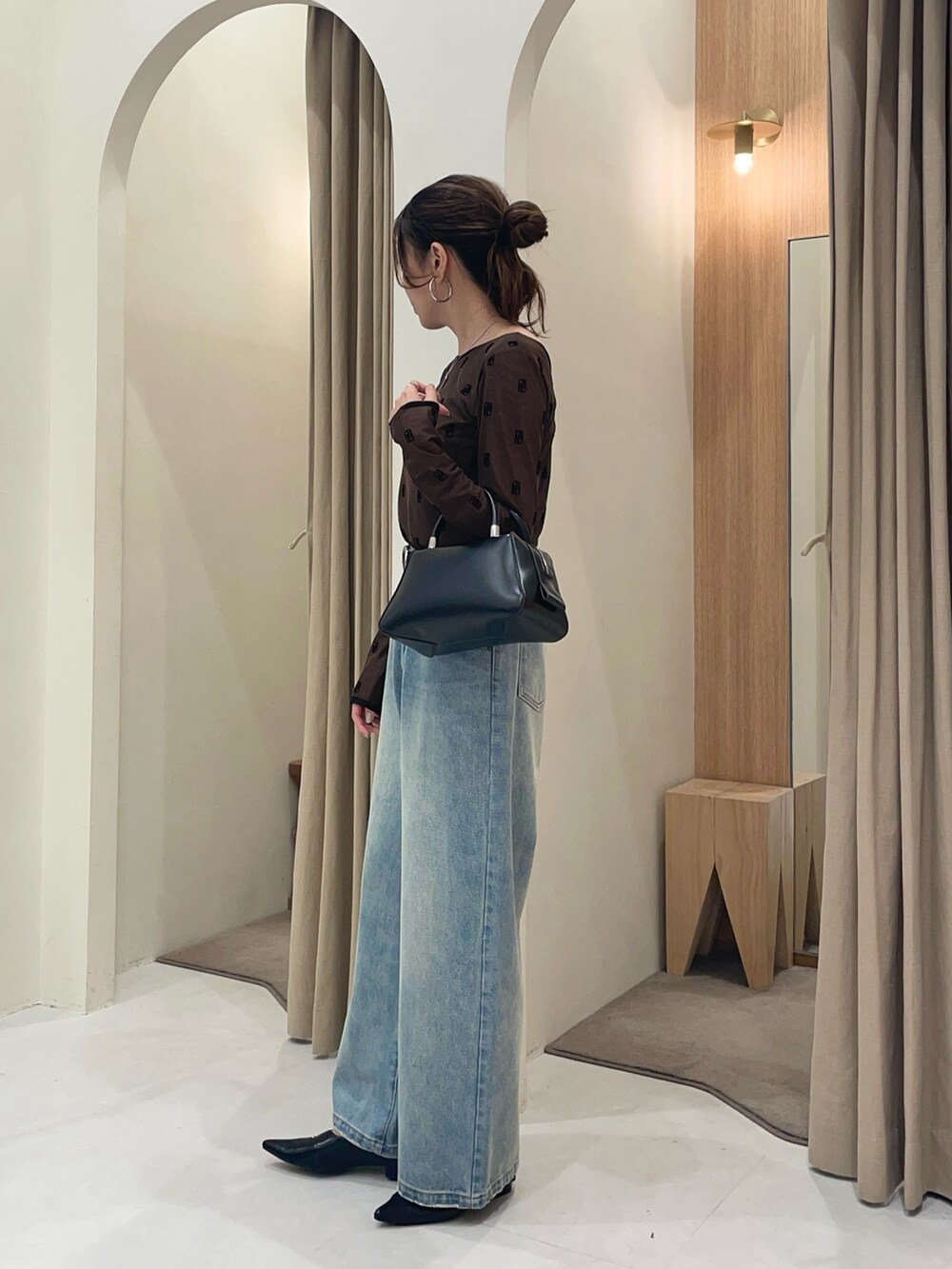 ブラウン系のTシャツ/カットソー、ブラック系のボストンバッグ、ブルー系のデニムパンツを着用したレディースの夏コーディネートの3枚目の写真