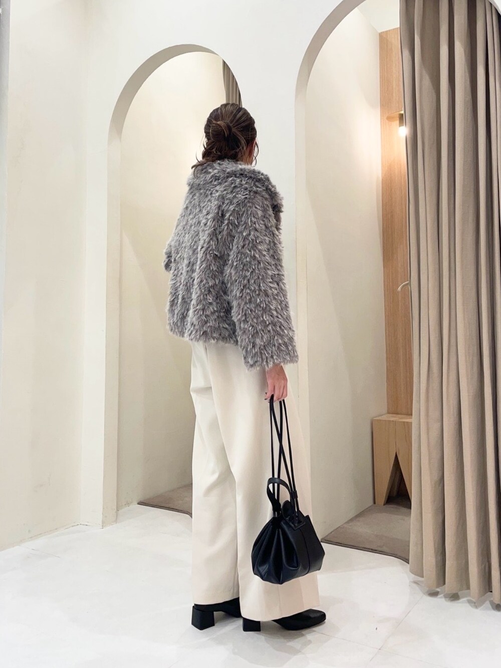 ブラック系のカーディガン/ボレロ、グレー系のその他アウター、ホワイト系のその他パンツを着用したレディースの冬コーディネートの2枚目の写真