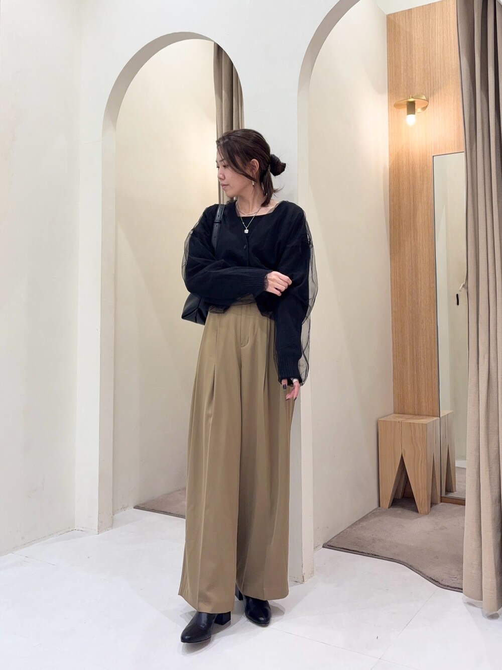 ブラック系のTシャツ/カットソー、ブラック系のカーディガン/ボレロ、ブラック系のショルダーバッグを着用したレディースの冬コーディネートの2枚目の写真