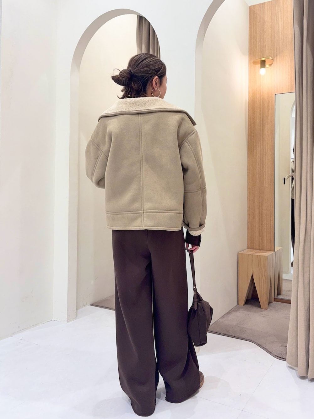 ブラウン系のTシャツ/カットソー、ベージュ系のその他アウター、ブラウン系のショルダーバッグを着用したレディースの冬コーディネートの2枚目の写真