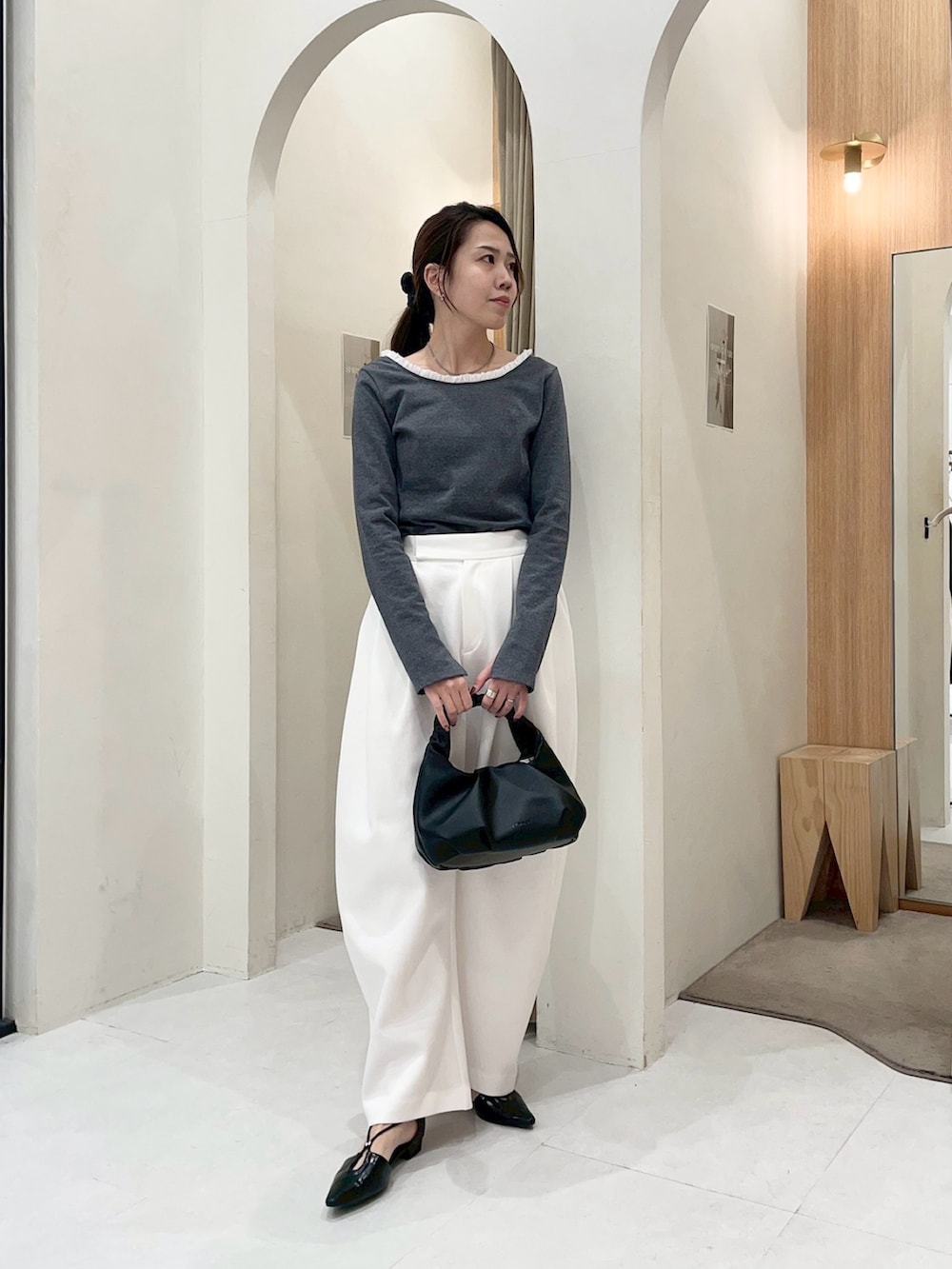 グレー系のTシャツ/カットソー、ホワイト系のその他パンツ、ブラック系のショルダーバッグを着用したレディースの春コーディネートの3枚目の写真