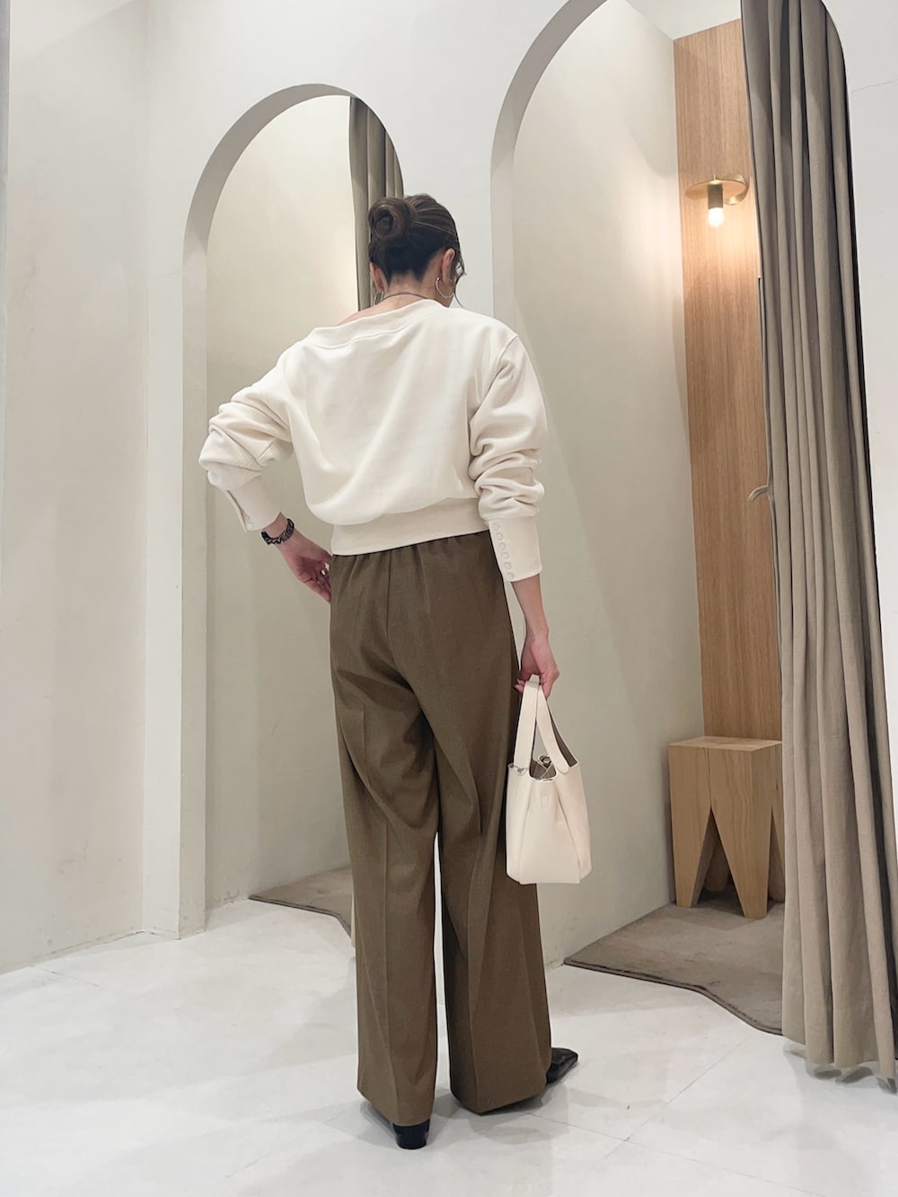 ホワイト系のTシャツ/カットソー、ホワイト系のショルダーバッグ、ブラウン系のその他パンツを着用したレディースの冬コーディネートの3枚目の写真