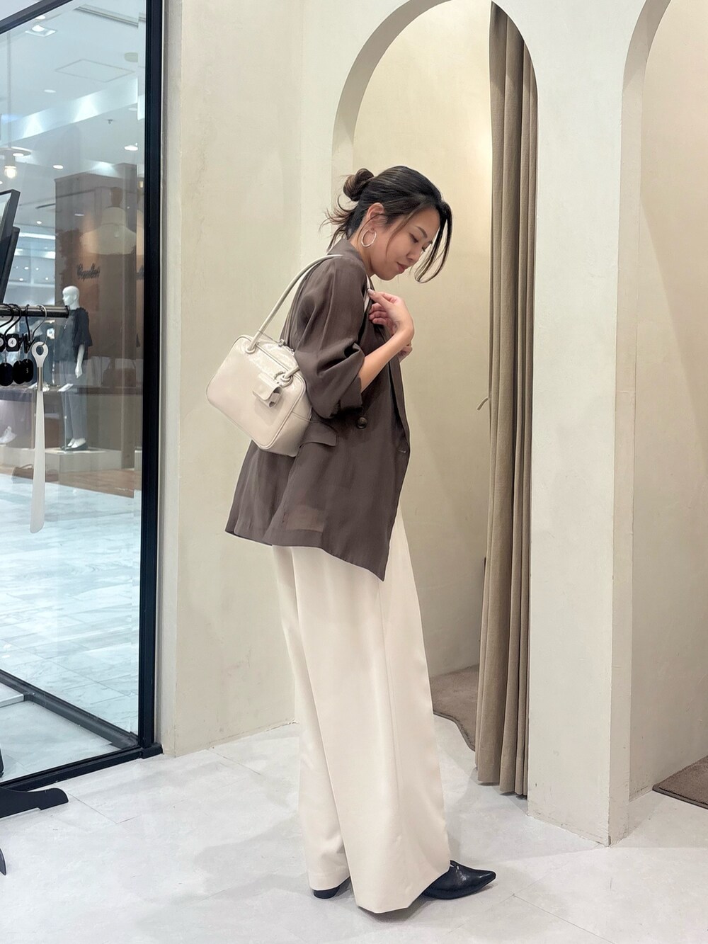 ホワイト系のその他パンツ、ブラック系のパンプス、ベージュ系のシャツ/ブラウスを着用したレディースの秋コーディネートの3枚目の写真