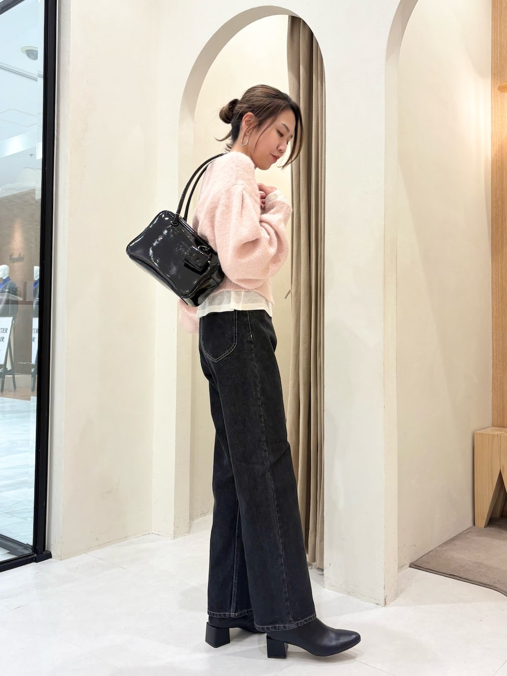 ピンク系のカーディガン/ボレロ、ブラック系のショルダーバッグ、ホワイト系のTシャツ/カットソーを着用したレディースの冬コーディネートの2枚目の写真