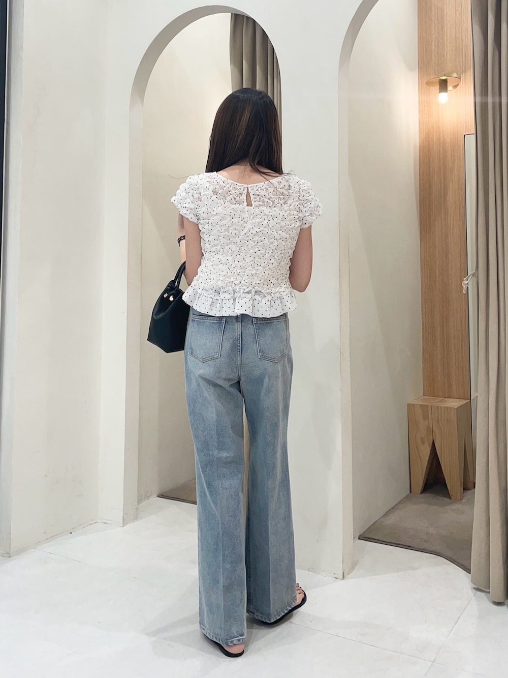 ホワイト系のシャツ/ブラウス、ブラック系のショルダーバッグ、ブルー系のデニムパンツを着用したレディースの夏コーディネートの2枚目の写真