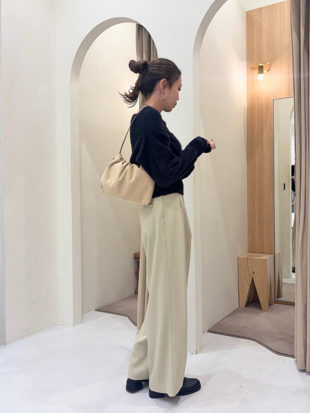 ブラック系のニット/セーター、ホワイト系のショルダーバッグ、ベージュ系のその他パンツを着用したレディースの秋コーディネートの3枚目の写真