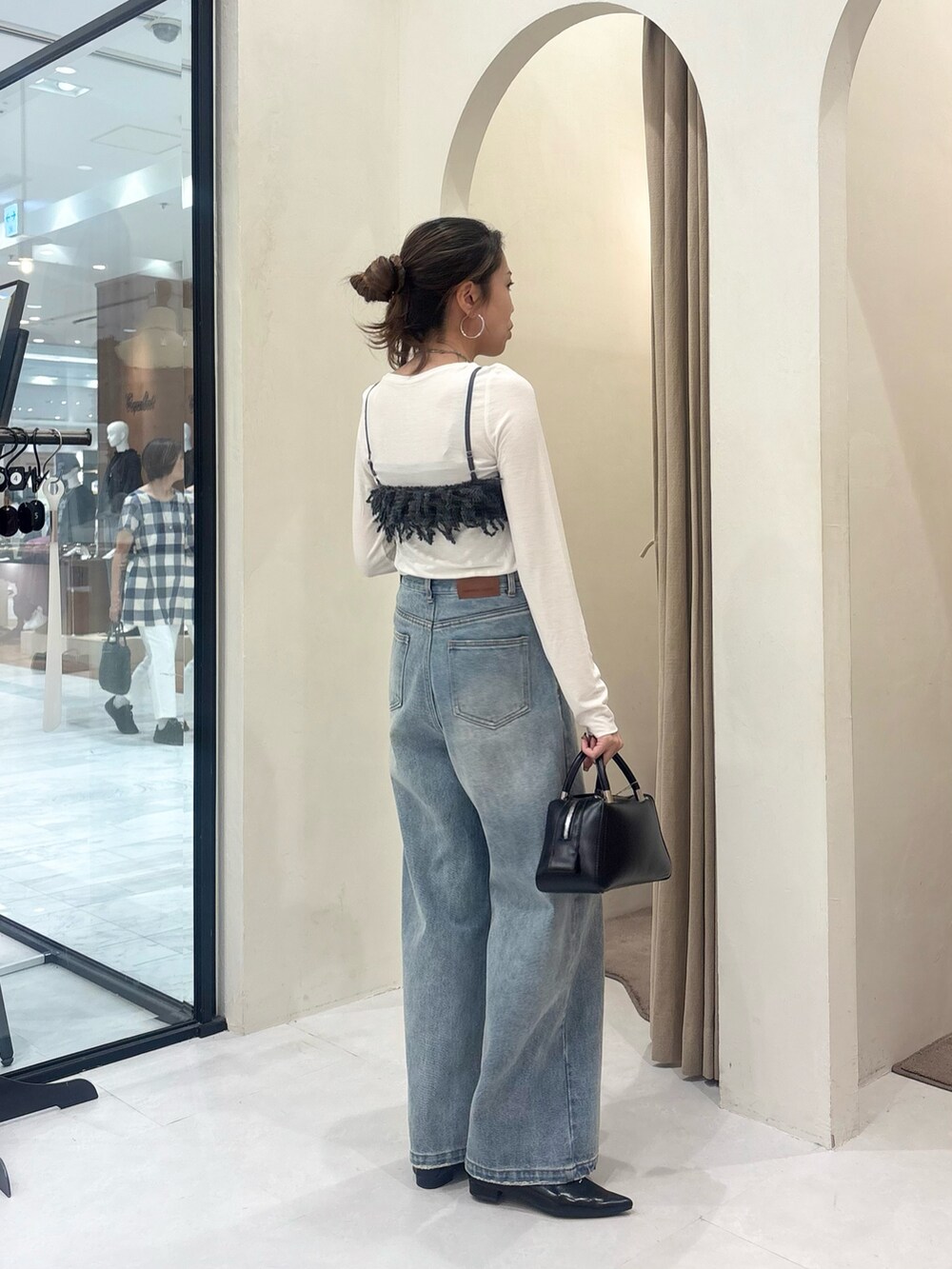 グレー系のTシャツ/カットソー、ブルー系のデニムパンツ、ブラック系のボストンバッグを着用したレディースの秋コーディネートの4枚目の写真