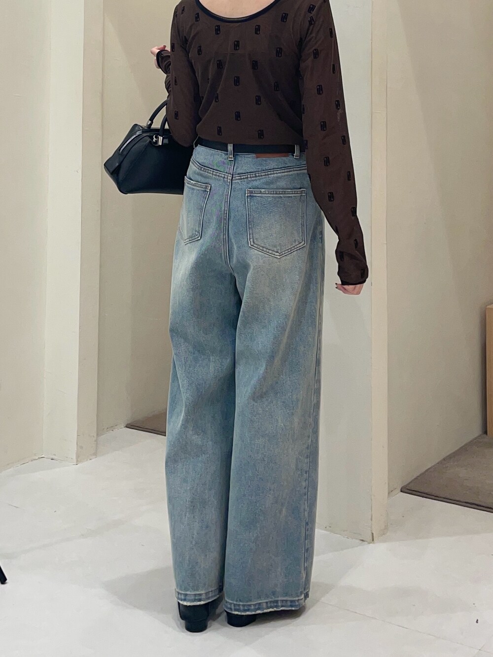 ブラウン系のTシャツ/カットソー、ブラック系のボストンバッグ、ブルー系のデニムパンツを着用したレディースの夏コーディネートの2枚目の写真