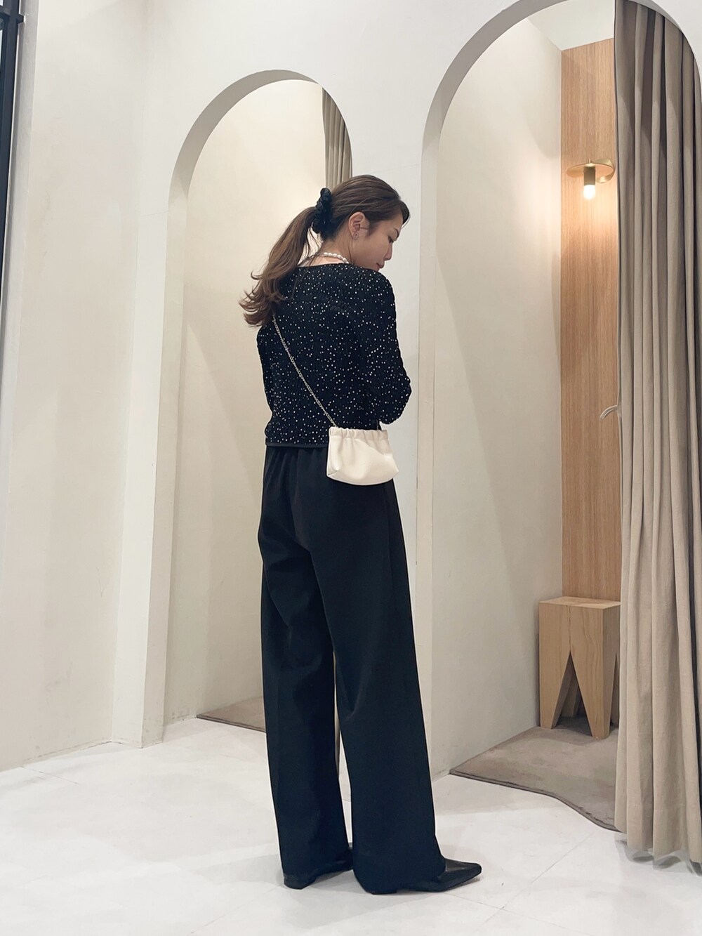 ホワイト系のショルダーバッグ、ブラック系のシャツ/ブラウス、ブラック系のその他パンツを着用したレディースの冬コーディネートの3枚目の写真