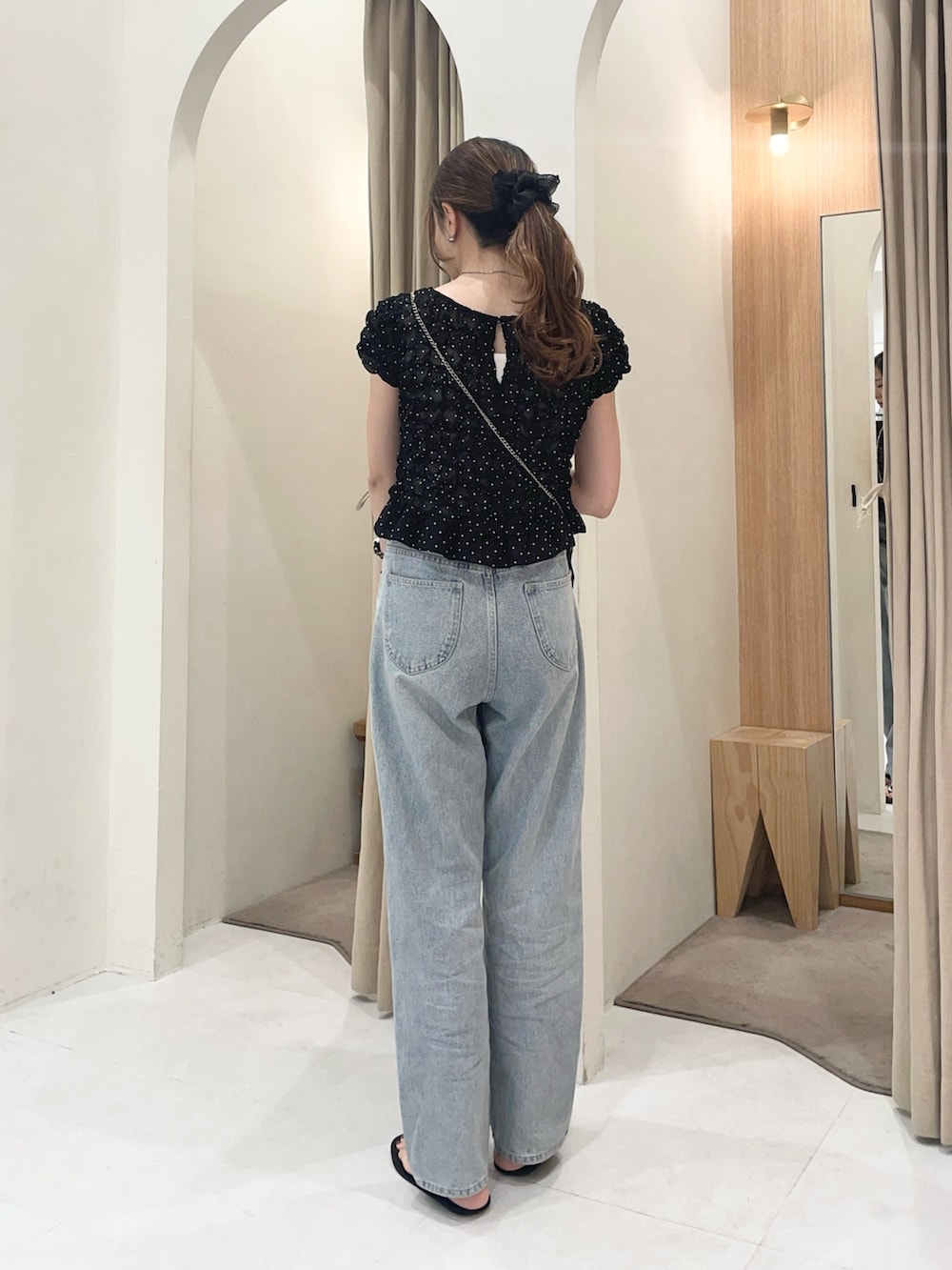 ブラック系のシャツ/ブラウス、ブラック系のショルダーバッグ、ブルー系のデニムパンツを着用したレディースの夏コーディネートの3枚目の写真