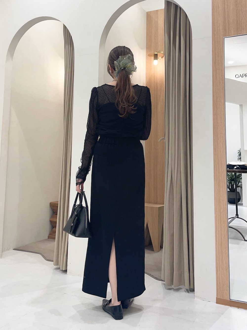 ブラック系のシャツ/ブラウス、ブラック系のスカート、ブラック系のショルダーバッグを着用したレディースの冬コーディネートの2枚目の写真