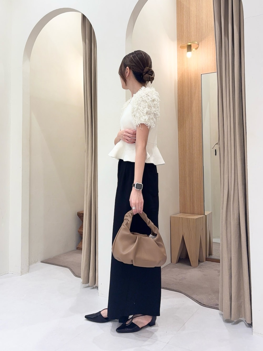 ホワイト系のニット/セーター、イエロー系のショルダーバッグ、ブラック系のスカートを着用したレディースの春コーディネートの2枚目の写真