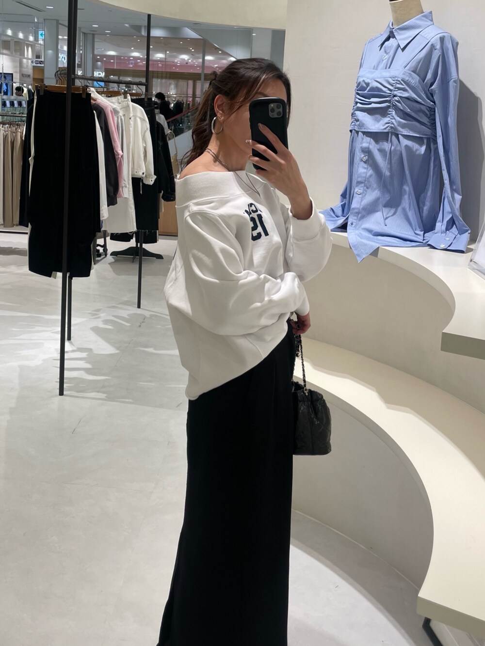ホワイト系のTシャツ/カットソー、ブラック系のスカート、ブラック系のショルダーバッグを着用したレディースの冬コーディネートの2枚目の写真