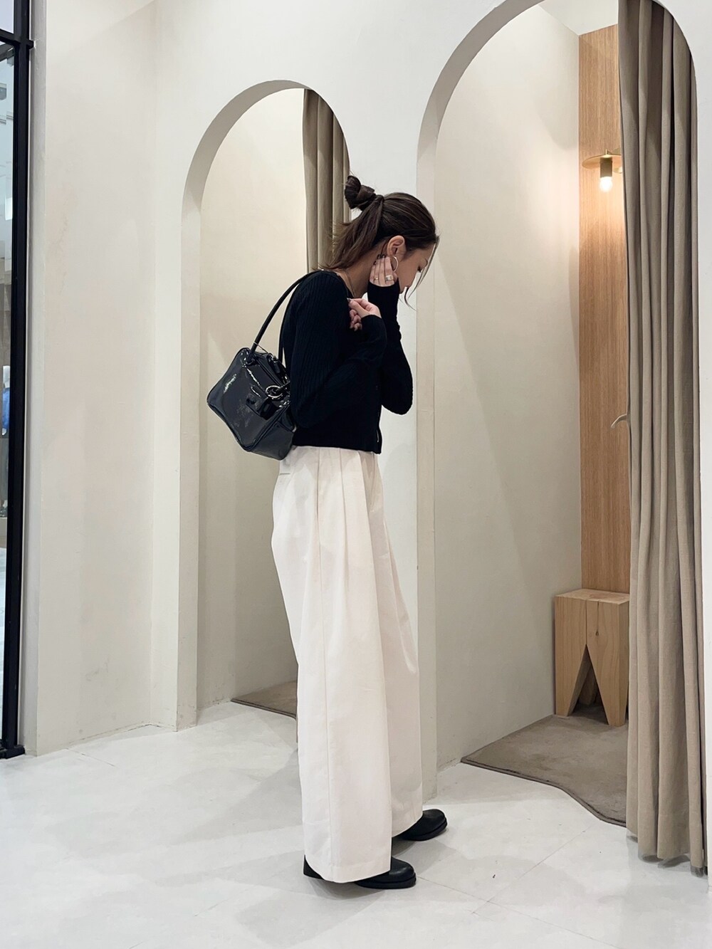 ブラック系のブルゾン、ブラック系のカーディガン/ボレロ、ホワイト系のその他パンツを着用したレディースの秋コーディネートの4枚目の写真