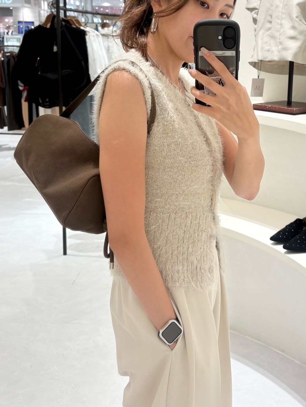 ベージュ系のニット/セーター、ブラウン系のショルダーバッグ、ホワイト系のその他パンツを着用したレディースの秋コーディネートの4枚目の写真