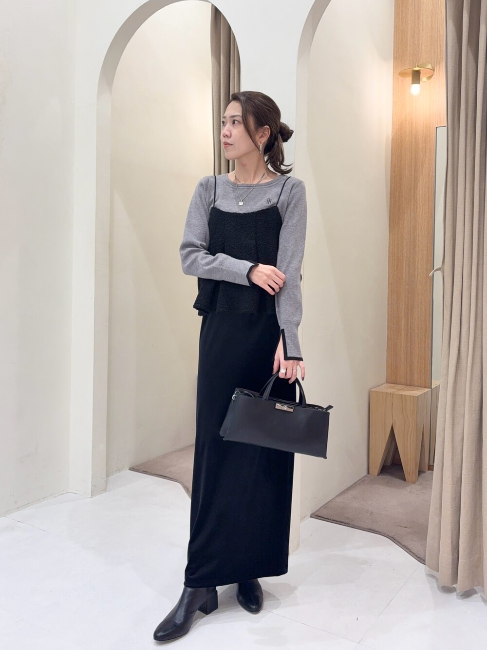 グレー系のニット/セーター、ブラック系のシャツ/ブラウス、ブラック系のスカートを着用したレディースの冬コーディネートの4枚目の写真
