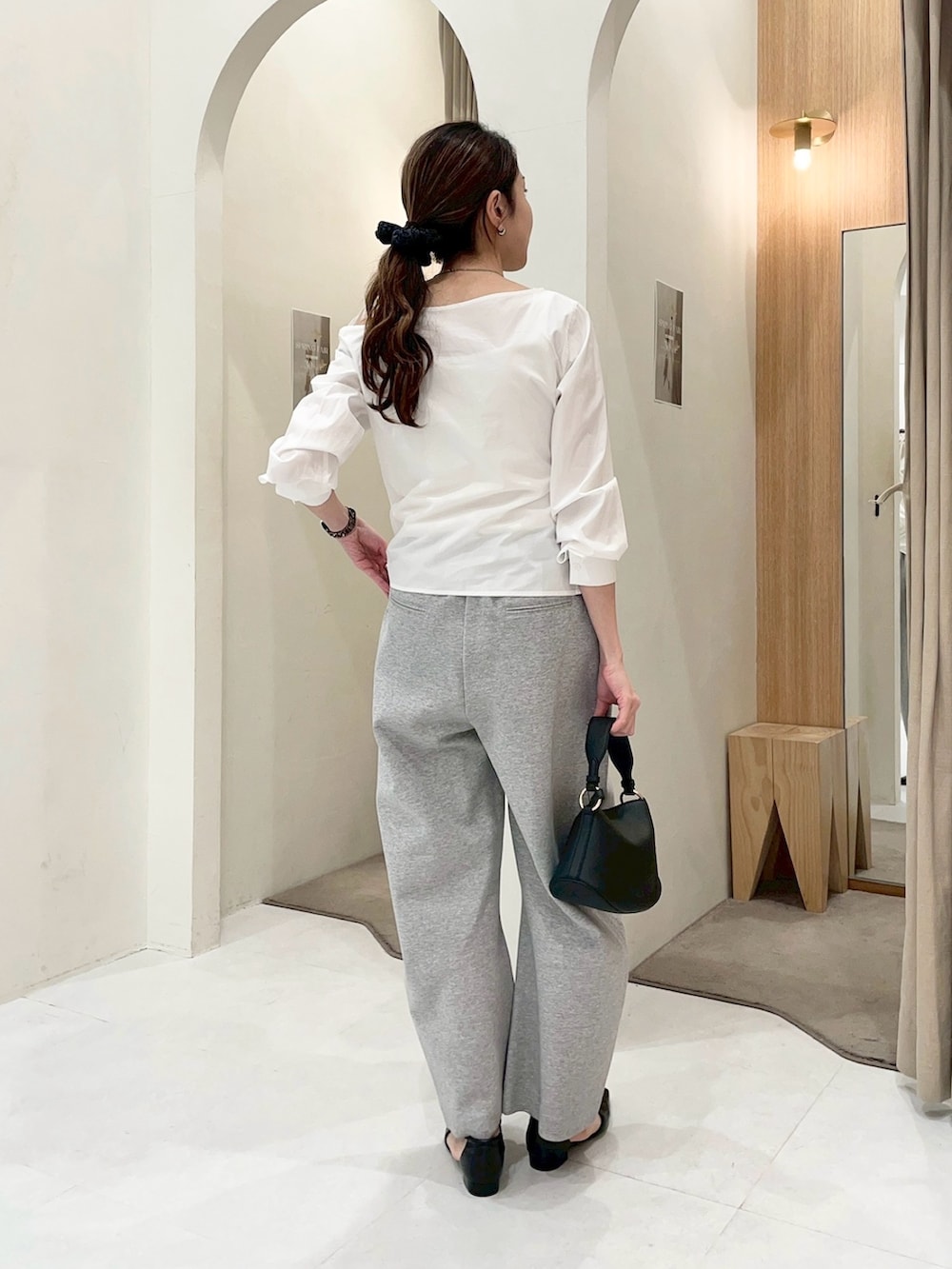 ホワイト系のシャツ/ブラウス、グレー系のその他パンツ、ブラック系のショルダーバッグを着用したレディースの春コーディネートの4枚目の写真
