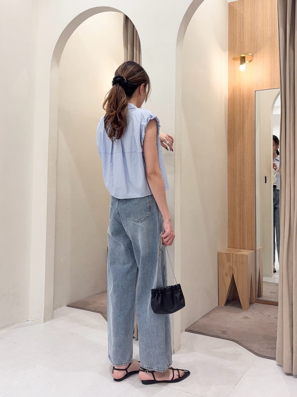 ブルー系のシャツ/ブラウス、ブルー系のデニムパンツ、ブラック系のショルダーバッグを着用したレディースの夏コーディネートの5枚目の写真
