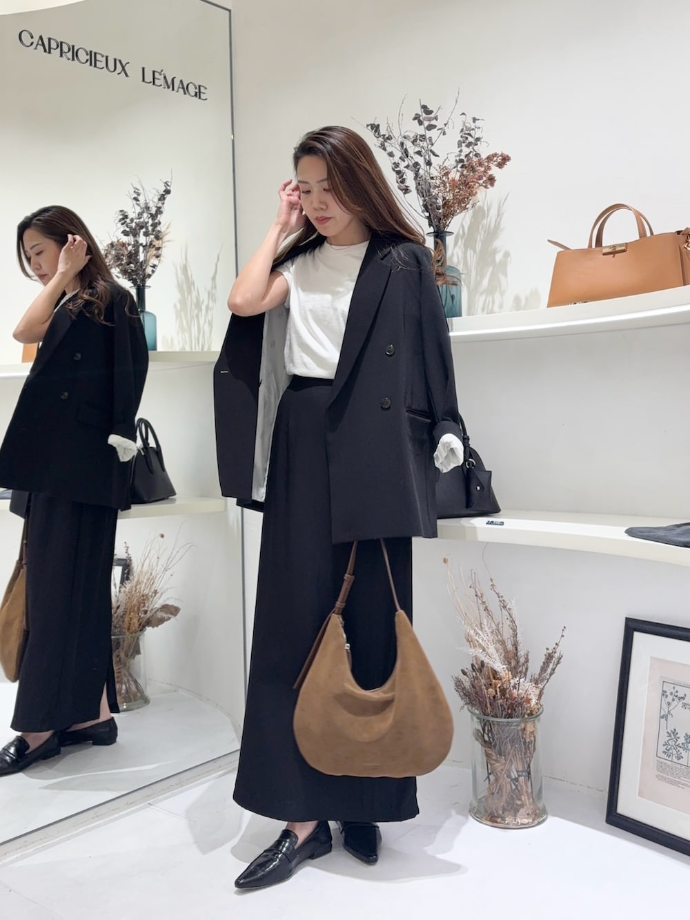 ホワイト系のTシャツ/カットソー、ブラック系のテーラードジャケット、ブラック系のスカートを着用したレディースの春コーディネートの5枚目の写真