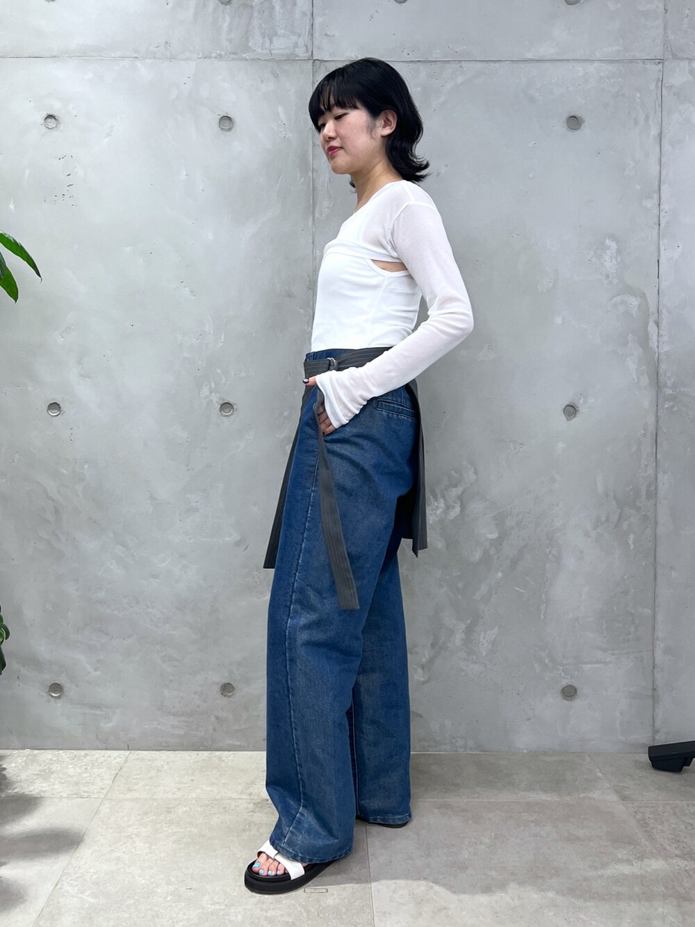 ホワイト系のタンクトップ、ブルー系のデニムパンツ、ホワイト系のサンダルを着用したレディースの夏コーディネートの2枚目の写真