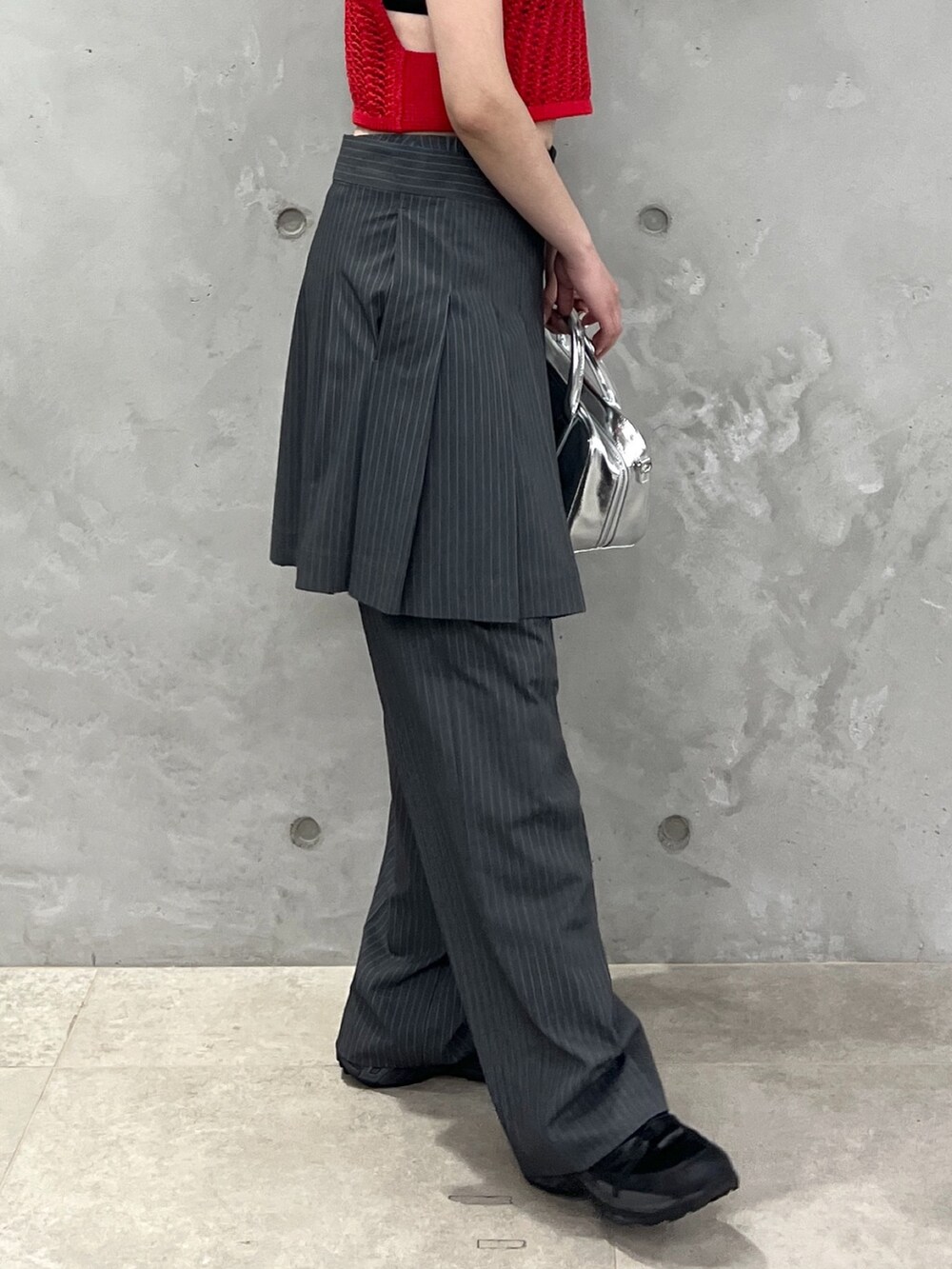 レッド系のベスト、グレー系のその他パンツ、シルバー系のボストンバッグを着用したレディースの夏コーディネートの7枚目の写真