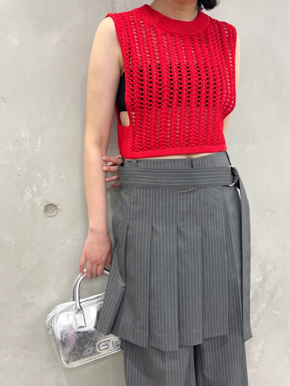 レッド系のベスト、グレー系のその他パンツ、シルバー系のボストンバッグを着用したレディースの夏コーディネートの4枚目の写真