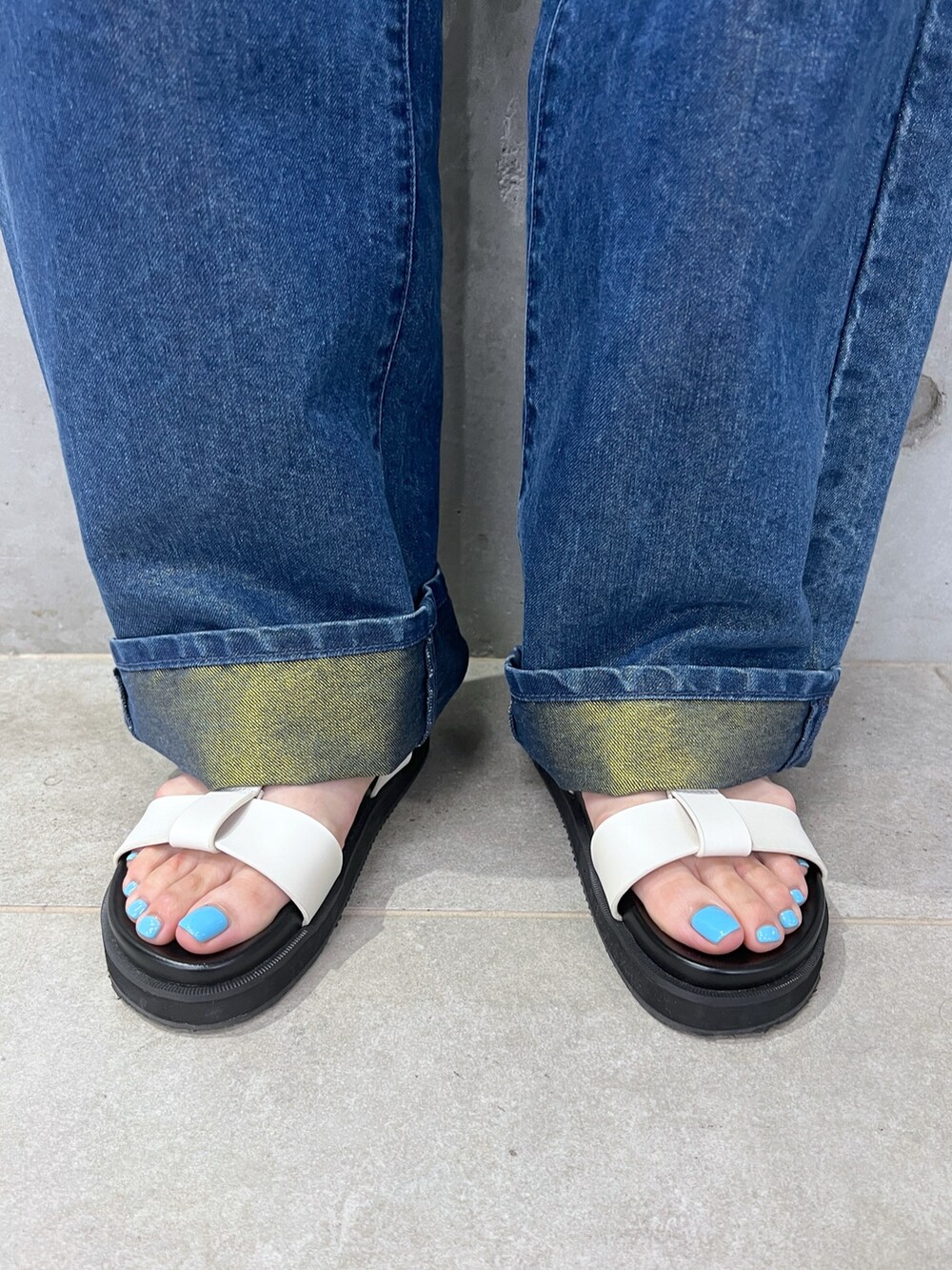 ホワイト系のタンクトップ、ブルー系のデニムパンツ、ホワイト系のサンダルを着用したレディースの夏コーディネートの10枚目の写真