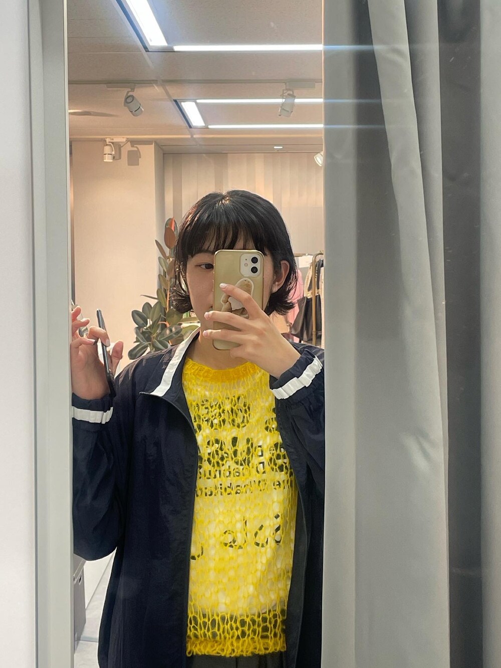 イエロー系のニット/セーター、ブルー系のブルゾン、グレー系のスラックスを着用したレディースの秋コーディネートの3枚目の写真