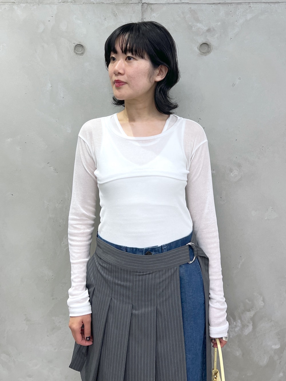 ホワイト系のタンクトップ、ブルー系のデニムパンツ、ホワイト系のサンダルを着用したレディースの夏コーディネートの4枚目の写真