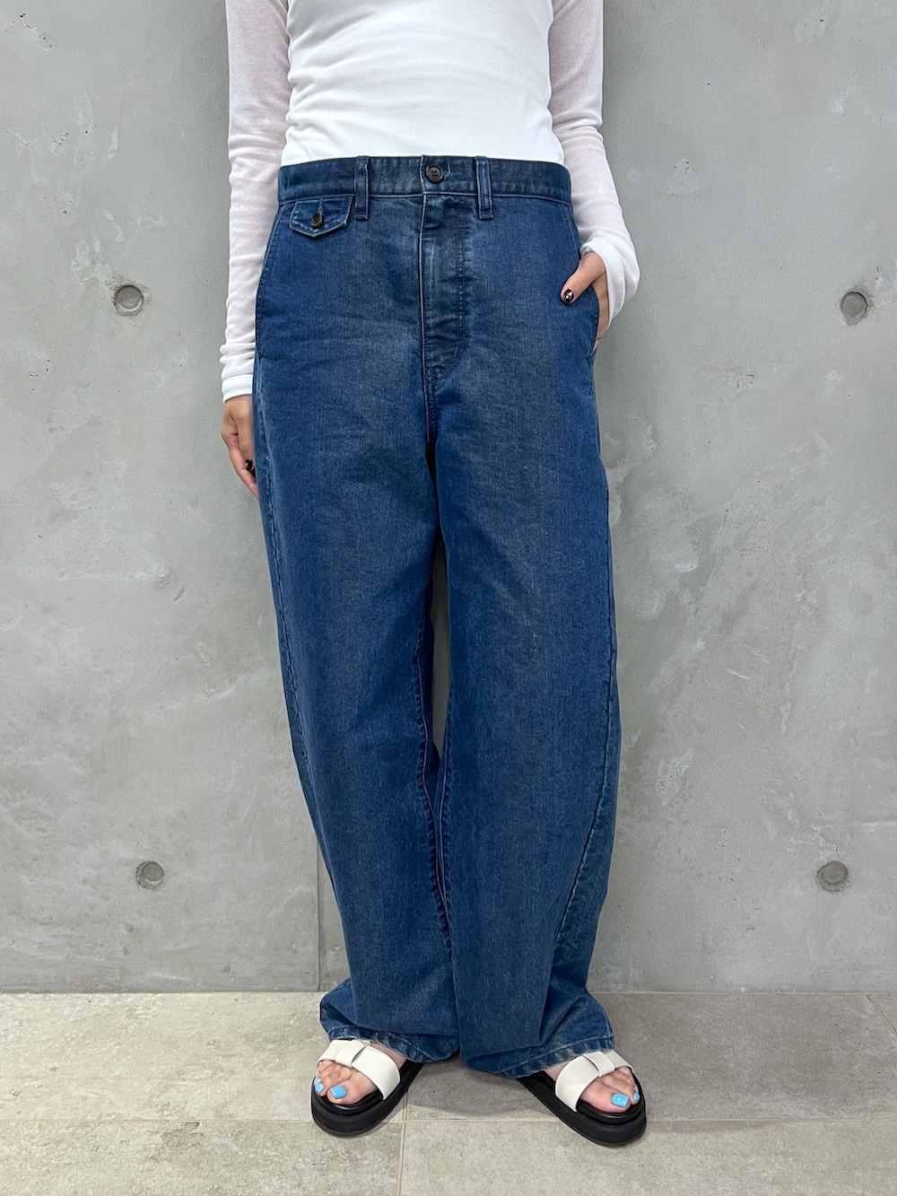 ホワイト系のタンクトップ、ブルー系のデニムパンツ、ホワイト系のサンダルを着用したレディースの夏コーディネートの9枚目の写真