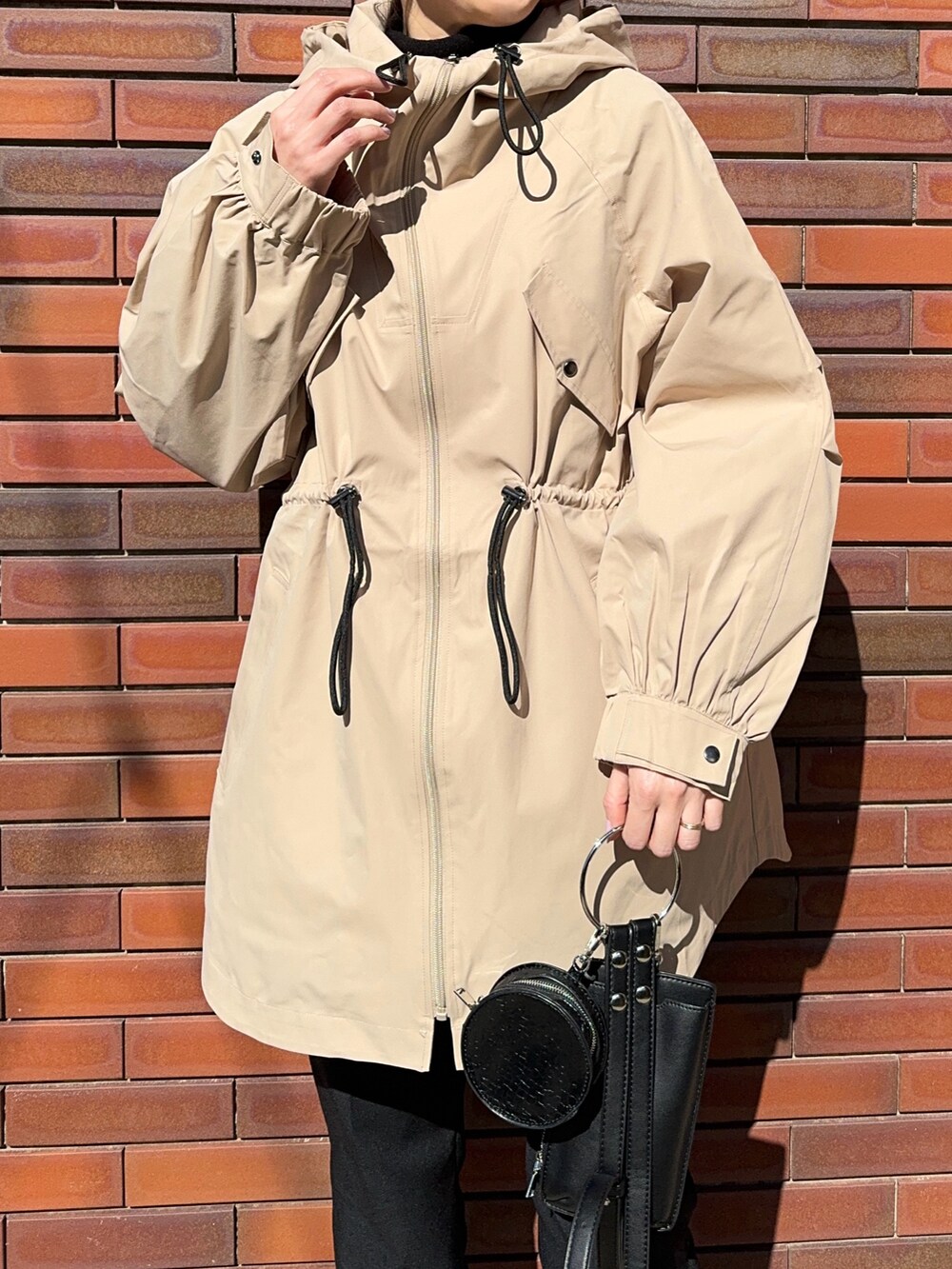 ベージュ系のジャケット/アウター、ブラック系のショルダーバッグ、ブラック系のスニーカーを着用したレディースの春コーディネートの3枚目の写真