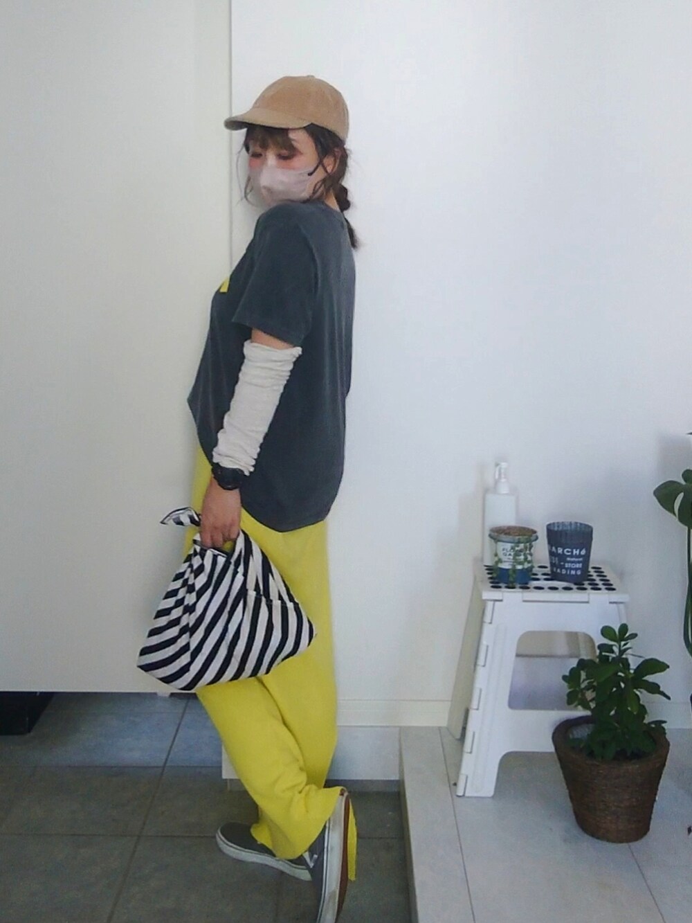 ブラック系のTシャツ/カットソー、イエロー系のスカート、ベージュ系のキャップを着用したレディースの秋コーディネートの5枚目の写真