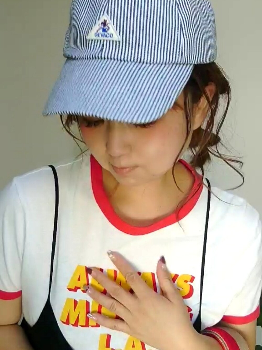 ブラック系のワンピース、レッド系のスニーカー、ブラック系のキャップを着用したレディースの秋コーディネートの4枚目の写真