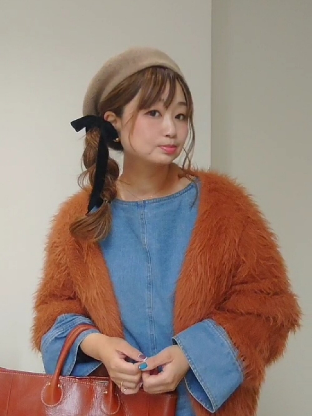 ブラウン系のカーディガン/ボレロ、ブルー系のシャツ/ブラウス、ブルー系のデニムパンツを着用したレディースの冬コーディネートの2枚目の写真