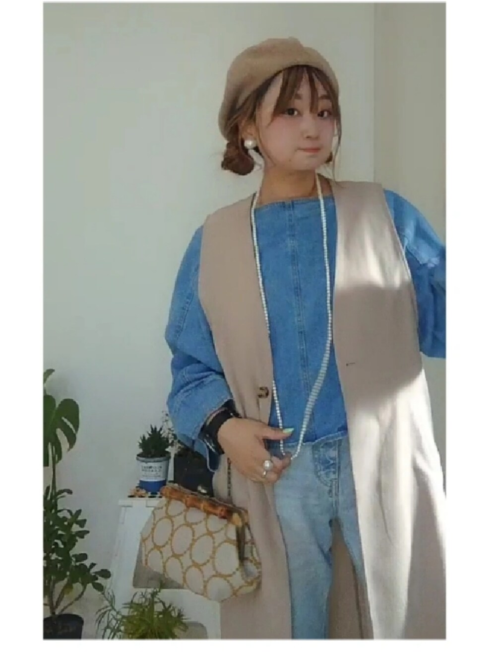 ブルー系のシャツ/ブラウス、ブルー系のデニムパンツ、ホワイト系のベストを着用したレディースの冬コーディネートの2枚目の写真
