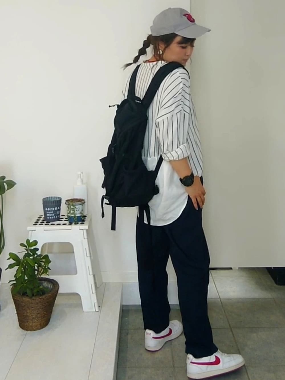 ブラック系のバックパック/リュック、ブルー系のその他パンツ、レッド系のスニーカーを着用したレディースの夏コーディネートの3枚目の写真