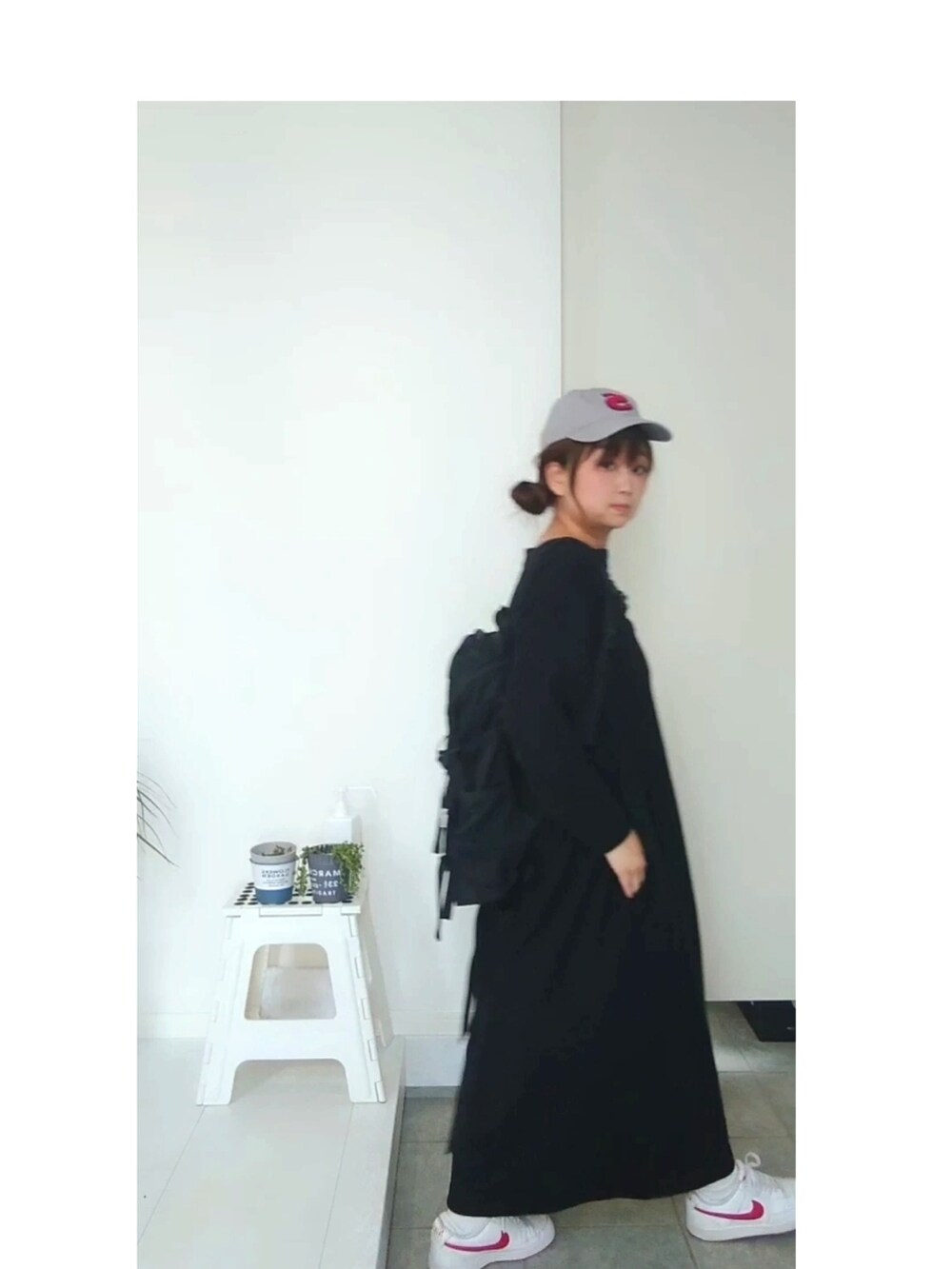 ブラック系のワンピース、レッド系のスニーカー、ブラック系のバックパック/リュックを着用したレディースの春コーディネートの2枚目の写真