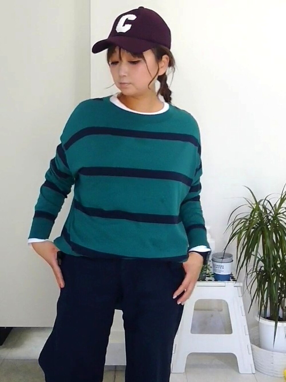 グリーン系のTシャツ/カットソー、ホワイト系のクラッチバッグ、ホワイト系のスニーカーを着用したレディースの春コーディネートの3枚目の写真