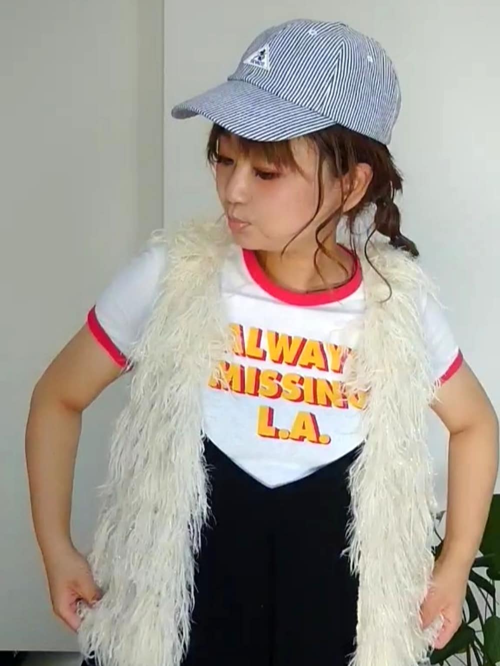 ブラック系のワンピース、レッド系のスニーカー、ブラック系のキャップを着用したレディースの秋コーディネートの2枚目の写真