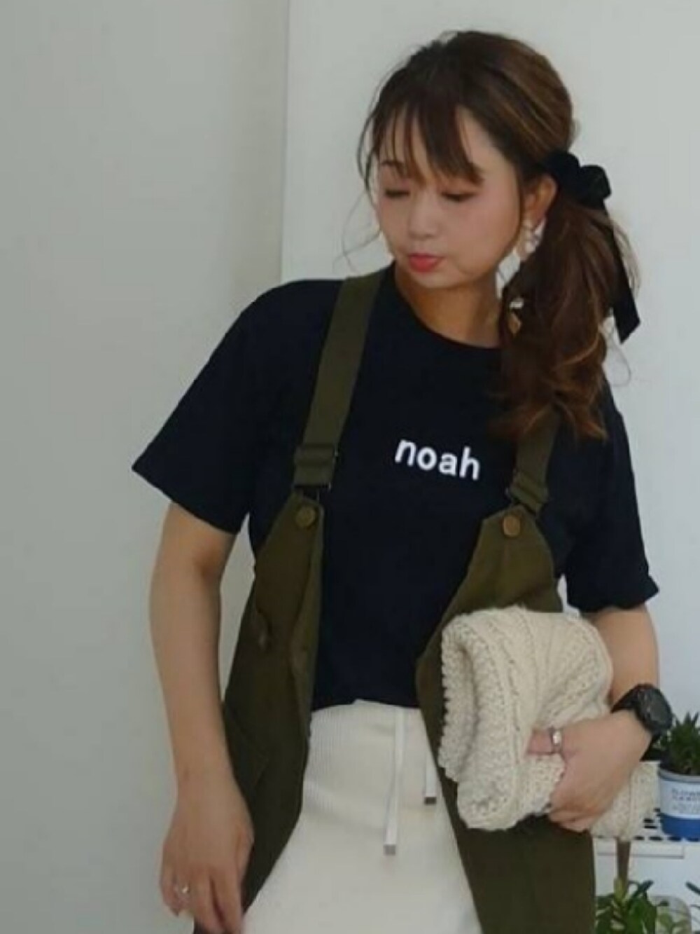 グリーン系のベスト、ブルー系のTシャツ/カットソー、ホワイト系のスカートを着用したレディースの秋コーディネートの2枚目の写真