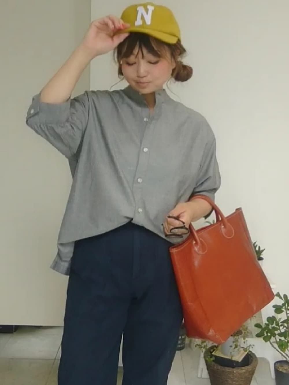 ブルー系のその他パンツ、グレー系のトップス、ブラウン系のトートバッグを着用したレディースの秋コーディネートの2枚目の写真
