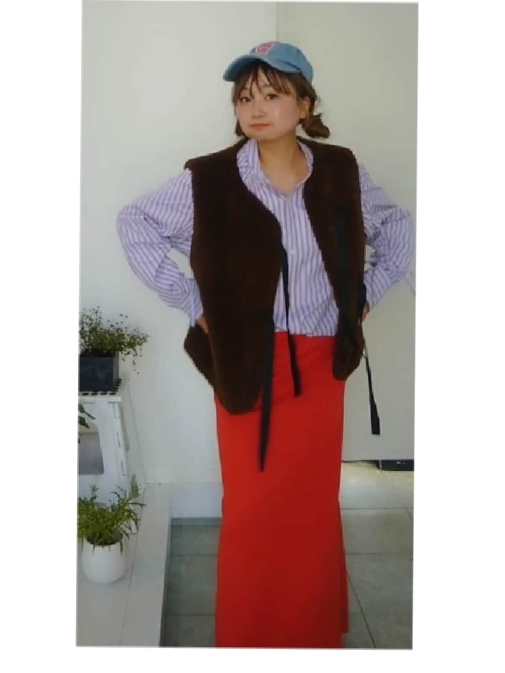 オレンジ系のスカート、ブラウン系のベスト、パープル系のシャツ/ブラウスを着用したレディースの秋コーディネートの3枚目の写真