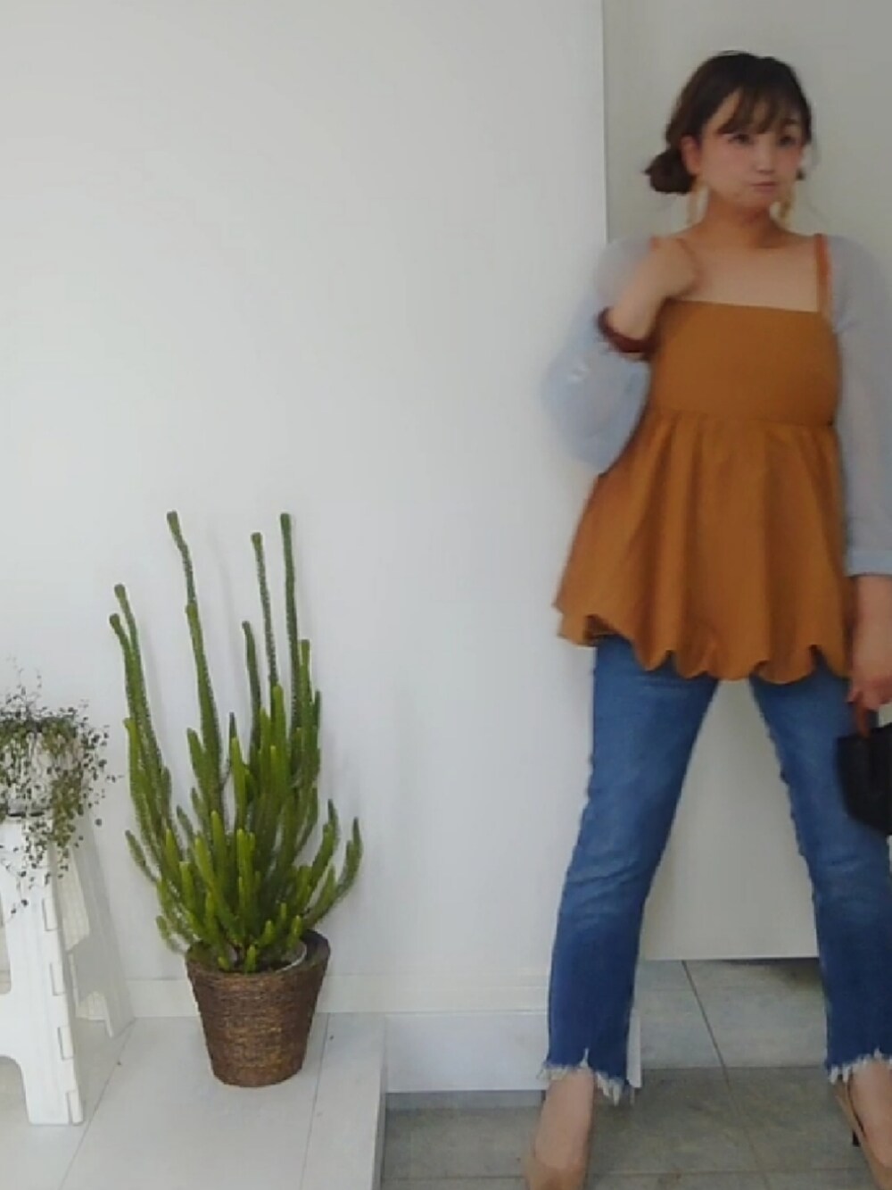 ブラック系のハンドバッグ、ブルー系のカーディガン/ボレロ、イエロー系のキャミソールを着用したレディースの夏コーディネートの3枚目の写真