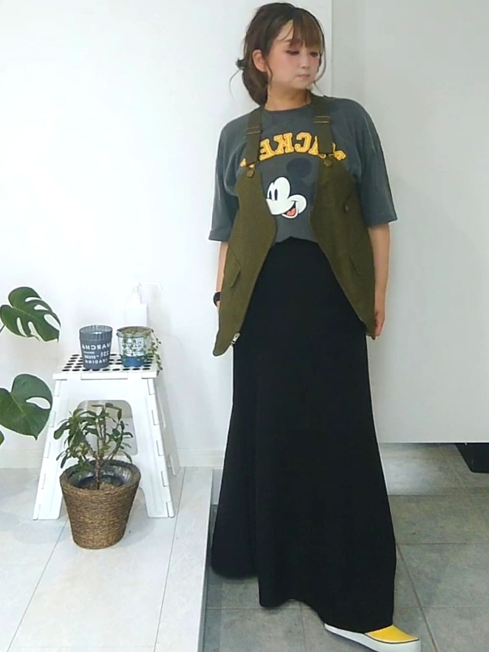 イエロー系のスニーカー、グリーン系のベストを着用したレディースの夏コーディネートの2枚目の写真