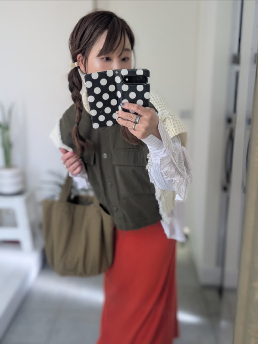 グリーン系のニット/セーターを着用したレディースの冬コーディネートの2枚目の写真