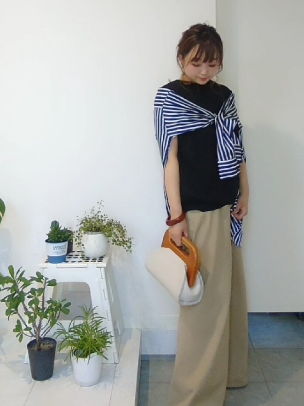 ブルー系のシャツ/ブラウス、ベージュ系のパンツ、ブラック系のニット/セーターを着用したレディースの夏コーディネートの3枚目の写真