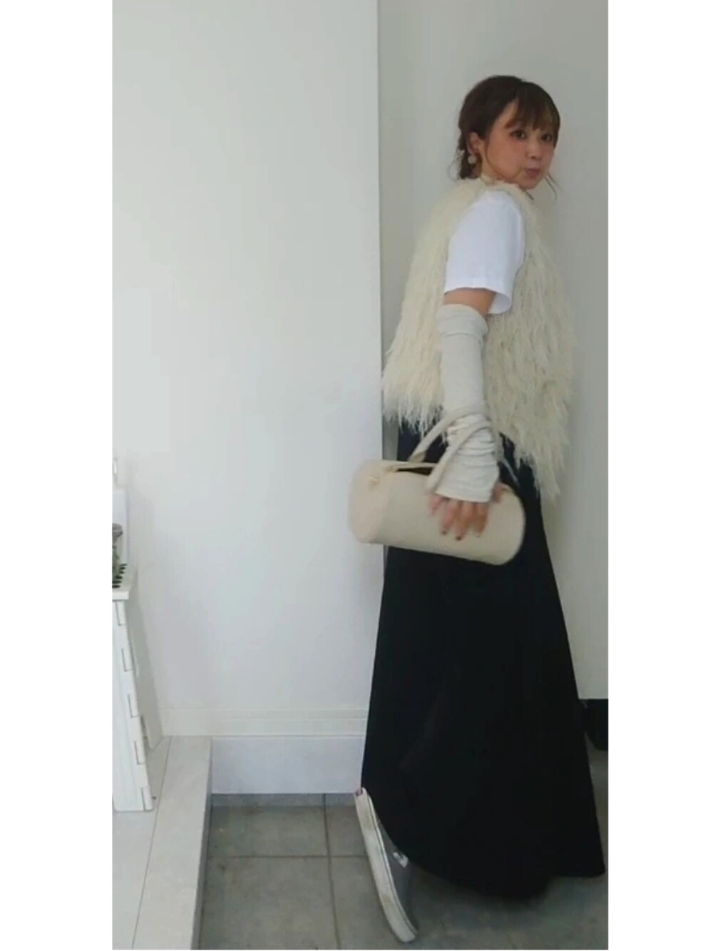 ホワイト系のTシャツ/カットソー、ブラック系のスカート、ホワイト系のショルダーバッグを着用したレディースの秋コーディネートの2枚目の写真