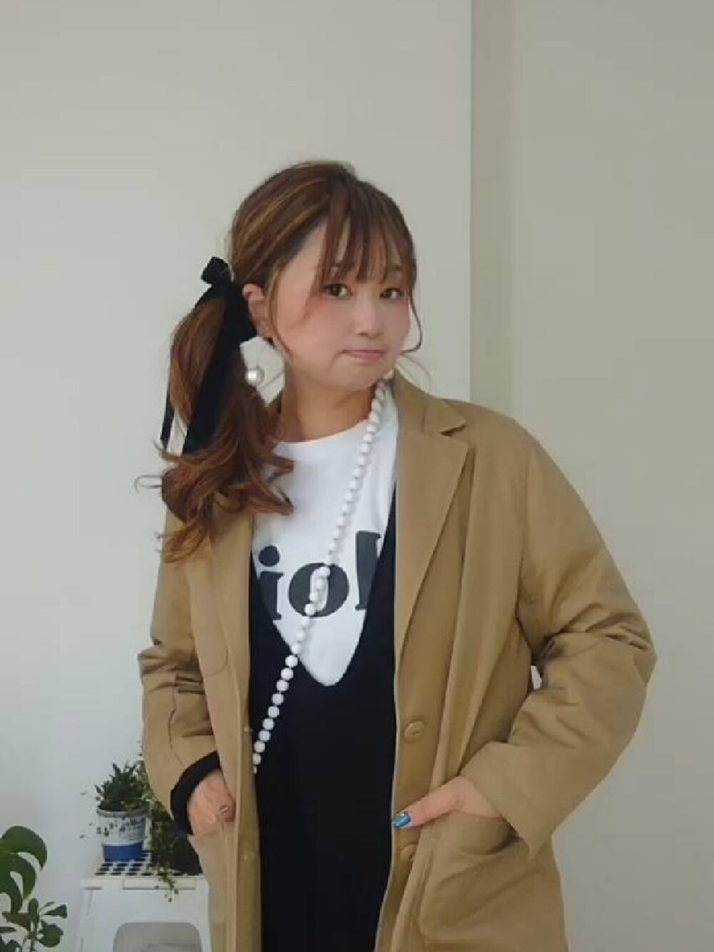 ブラック系のワンピース、ホワイト系のTシャツ/カットソー、ホワイト系のスマホグッズを着用したレディースの冬コーディネートの3枚目の写真