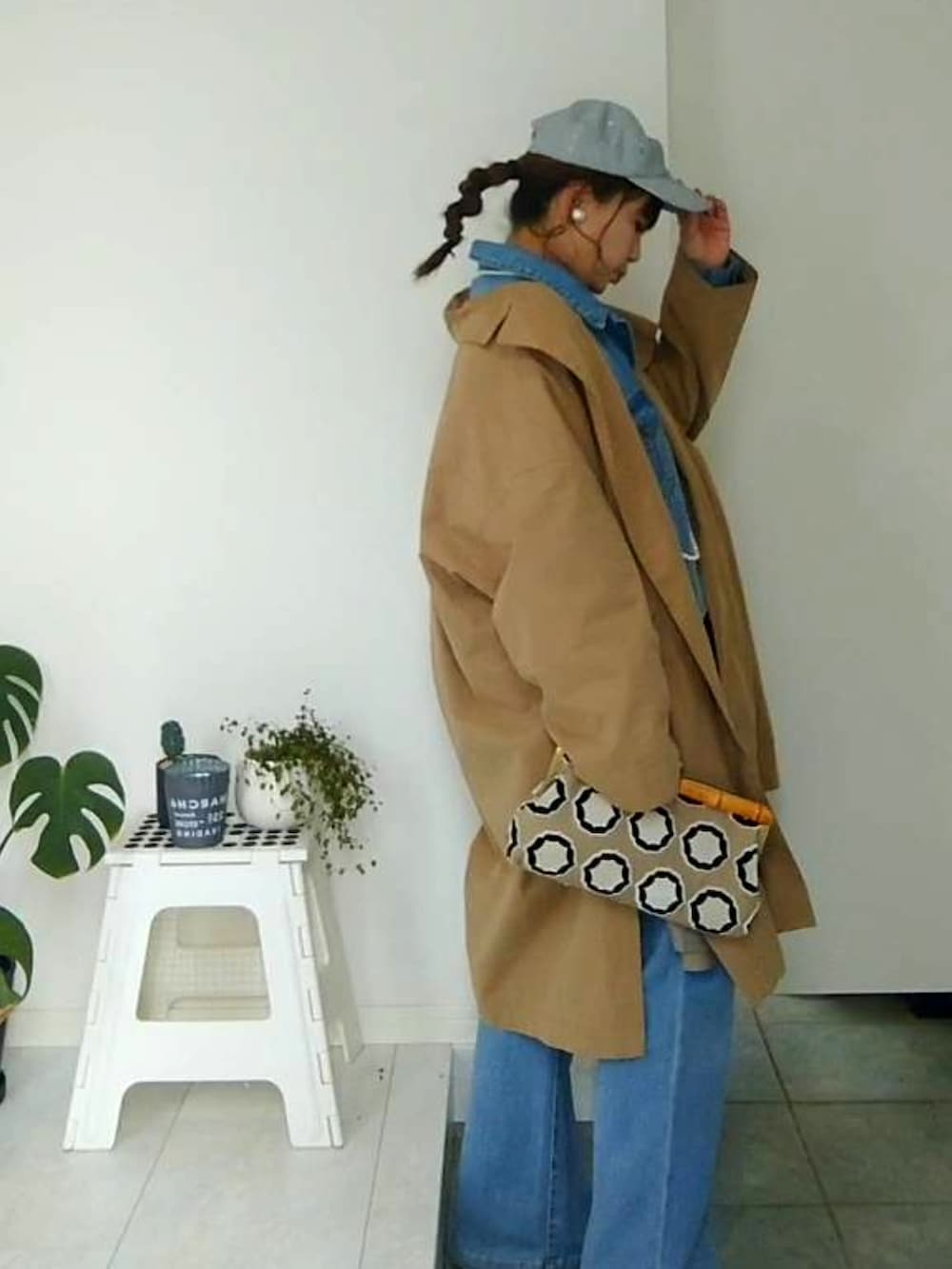 ブルー系のデニムジャケット、ブルー系のデニムパンツ、ベージュ系のクラッチバッグを着用したレディースの冬コーディネートの5枚目の写真